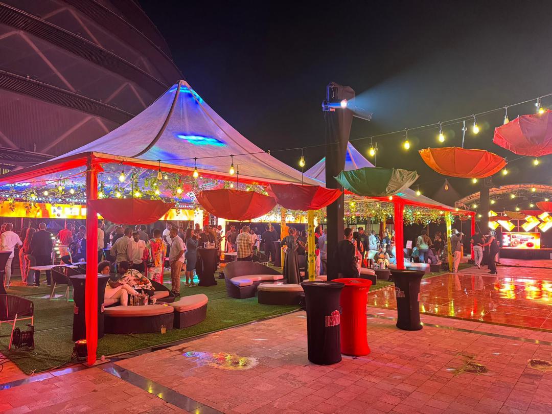 Night brand event with lit tents, umbrellas and lounge seating at KCC Piazza